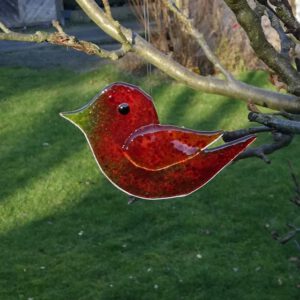 Roter Glasvogel als Gartendekoration zum Aufhängen. Ein frühlinghaftes Mitbringsel.