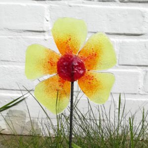 Im Glasfusing hergestellte Blume aus Glas, die auf einem Metallstab steckt und so in Boden oder Blumentopf gesteckt werden kann.